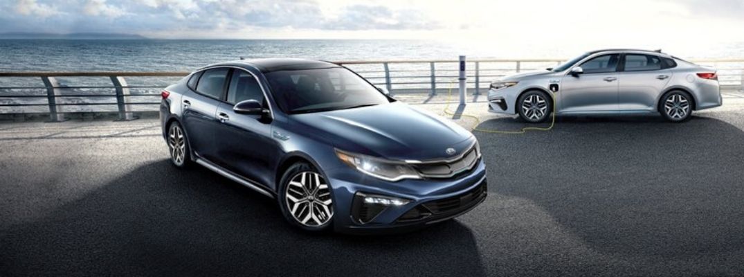 Exterior view of a blue 2020 Kia Optima Hybrid and a silver 2020 Kia Optima Plug-In Hybrid
