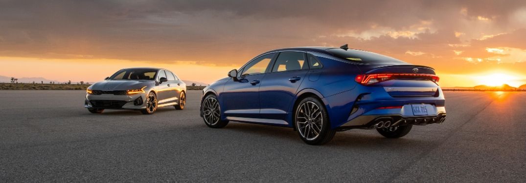 Exterior view of a blue 2021 Kia K5 and a gray 2021 Kia K5