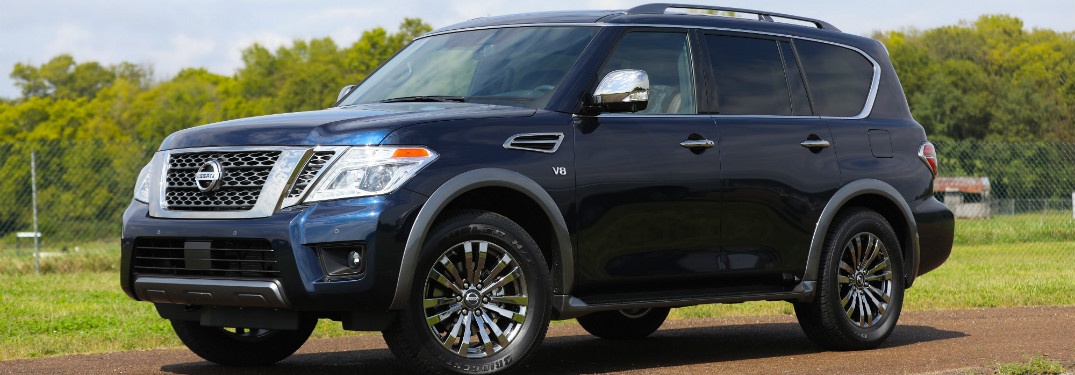 front and side view of blue 2018 nissan armada against green trees and grass