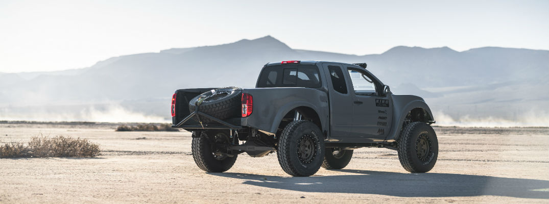 A right rear profile photo of the Nissan Frontier Desert Runner parked in the desert.