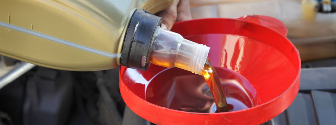 A stock photo of oil being added to an engine.
