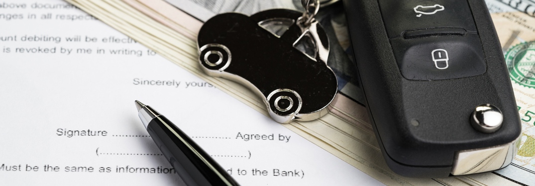 Paperwork and pen with keys and cash for a vehicle