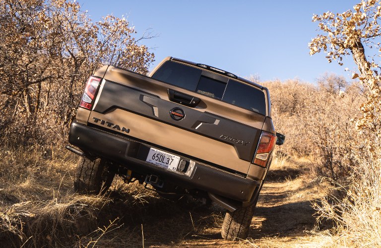 2021 Nissan TITAN driving away through the brush