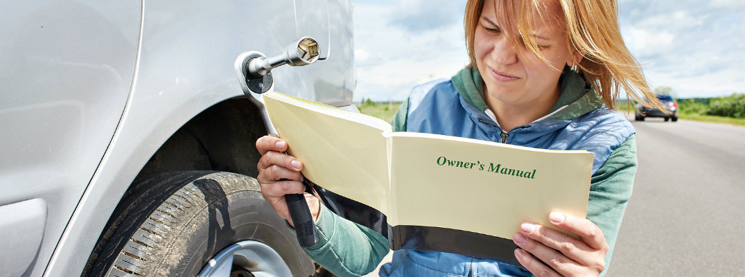 Woman reading the owner's manual of her vehicle