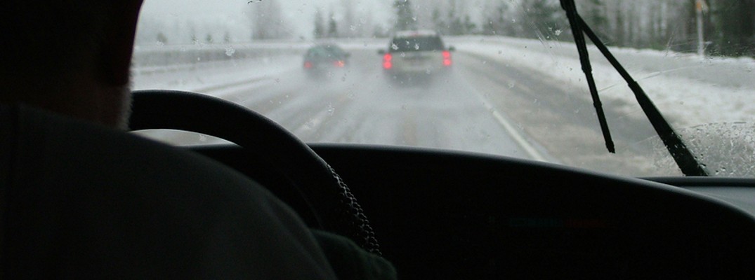 Looking through windshield at cars on road during winter