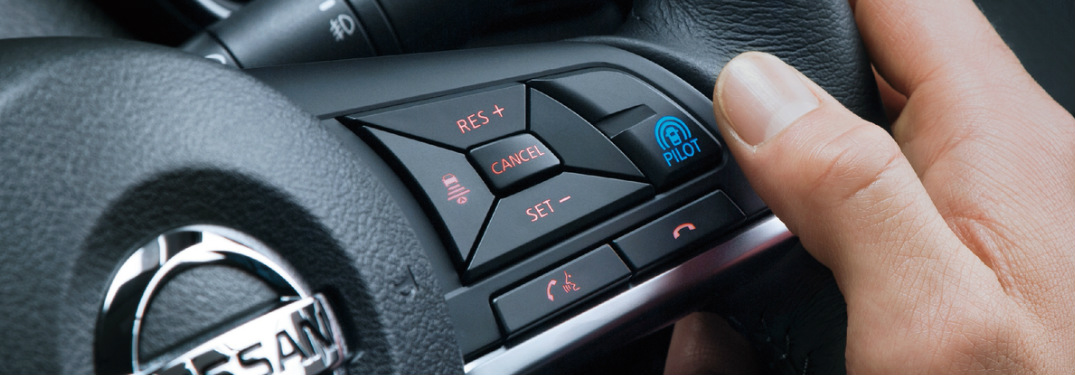 Someone about to press the Nissan ProPILOT Assist button on a steering wheel