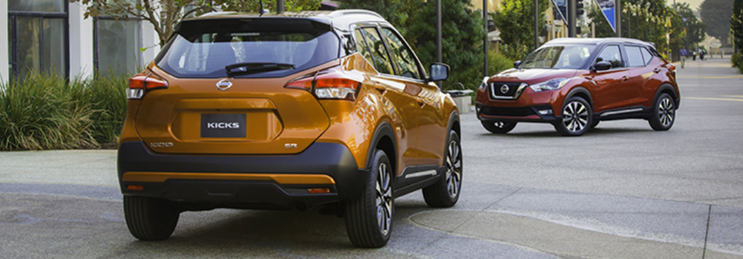 Two 2018 Nissan Kicks models parked on an empty concrete walkway