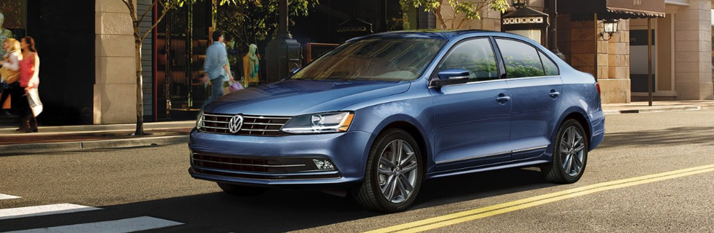 Blue 2018 Volkswagen Jetta parked in front of a store