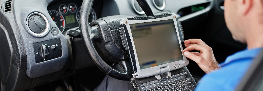 Mechanic in car with computer