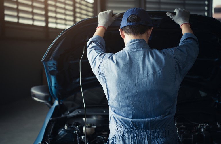 Mechanic looking under the hood of a car