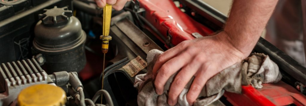 man working on engine changing oil