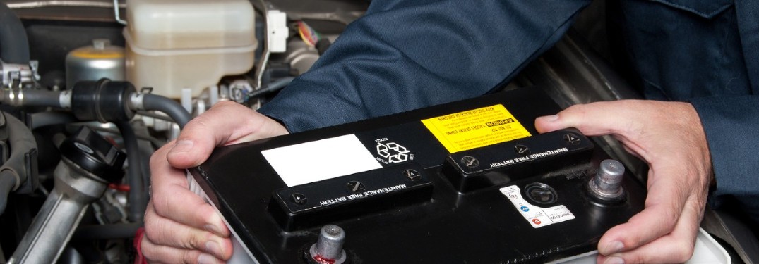 two hands with a car battery
