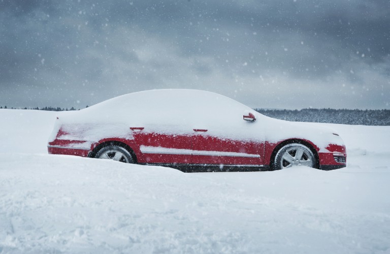 red car in a lot of snow