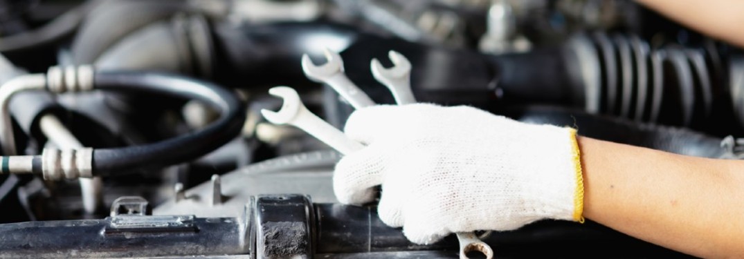 a white-gloved hand holding some tools
