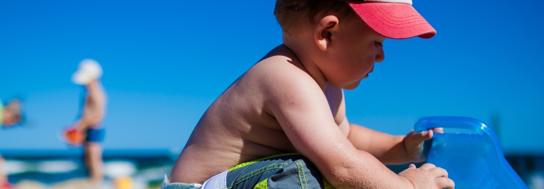 a baby playing in the sand at a beach