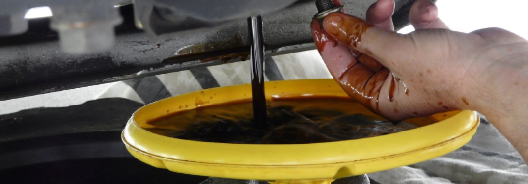 engine oil being poured into a yellow funnel