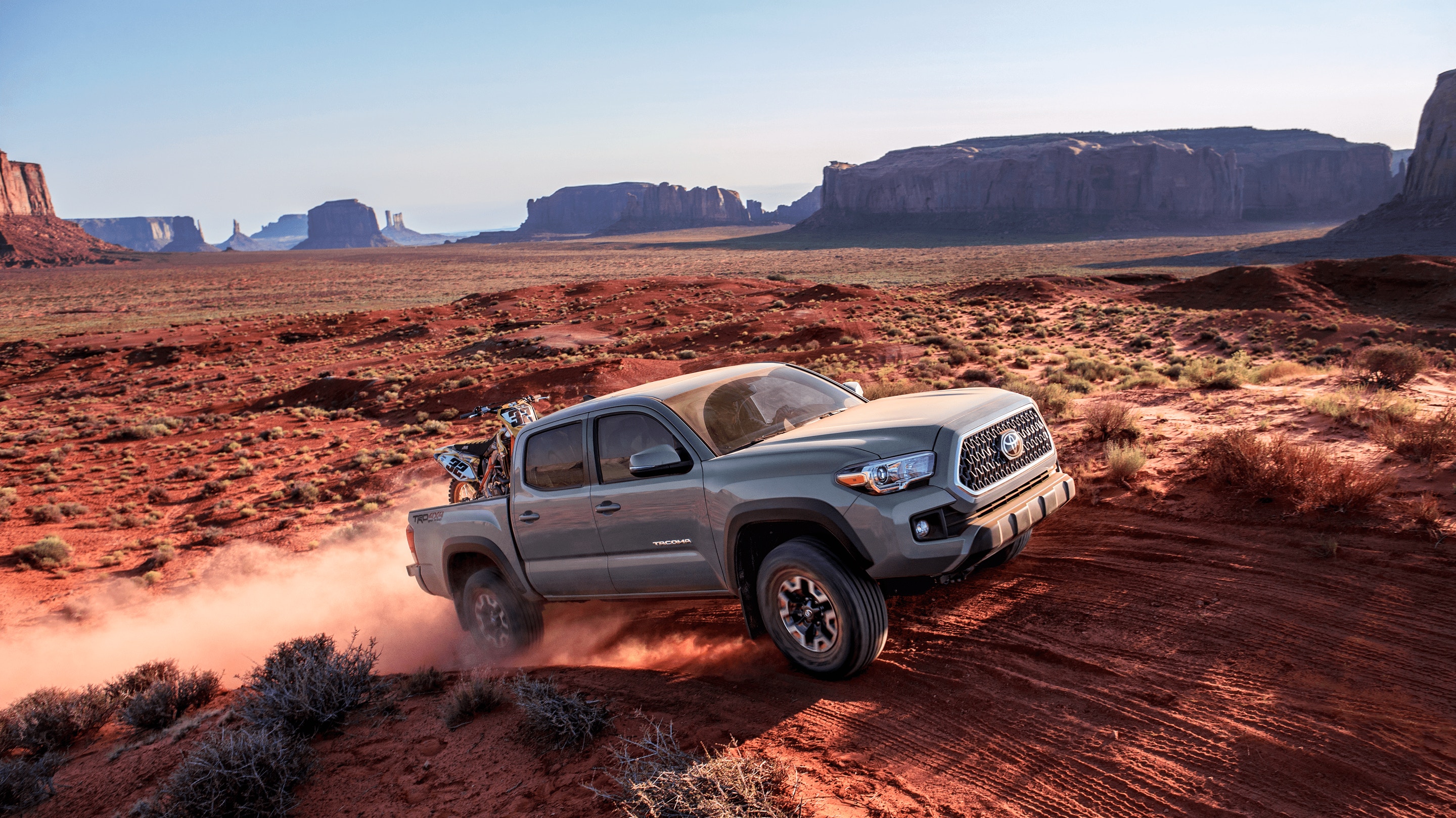 Image of a gray Toyota Tacoma truck driving off-road in the desert.
