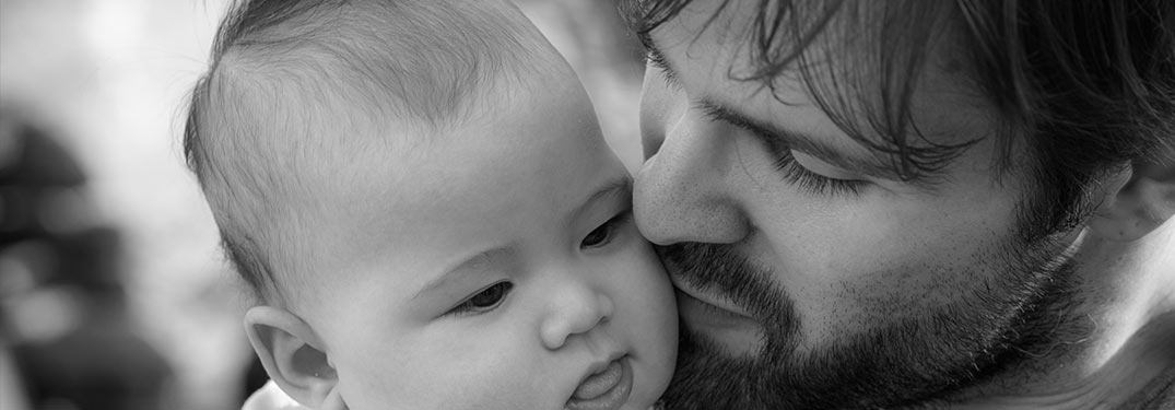 Father holding infant sun black and white