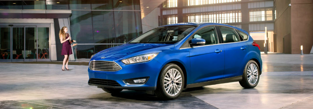 2018 Ford Focus hatchback exterior front fascia and drivers side with woman standing off to side