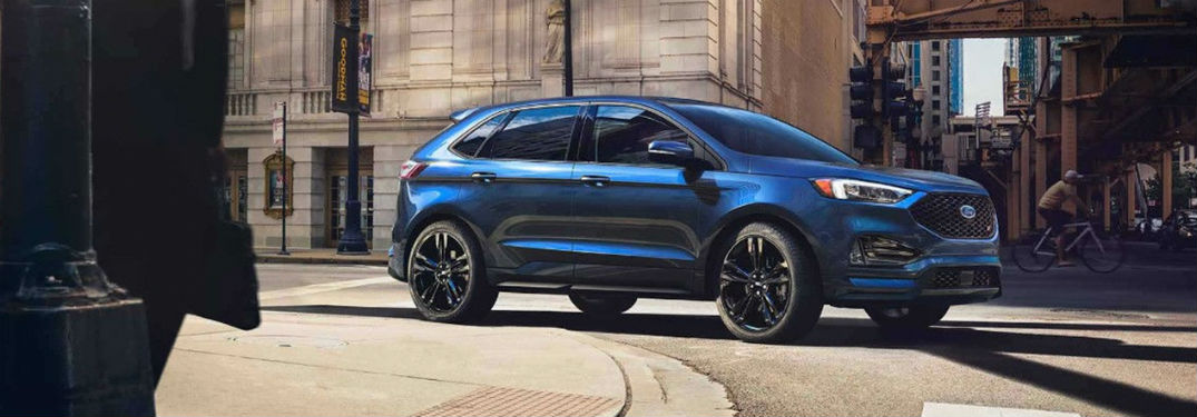 2019 Ford Edge exterior front fascia and passenger side on city road with person biking