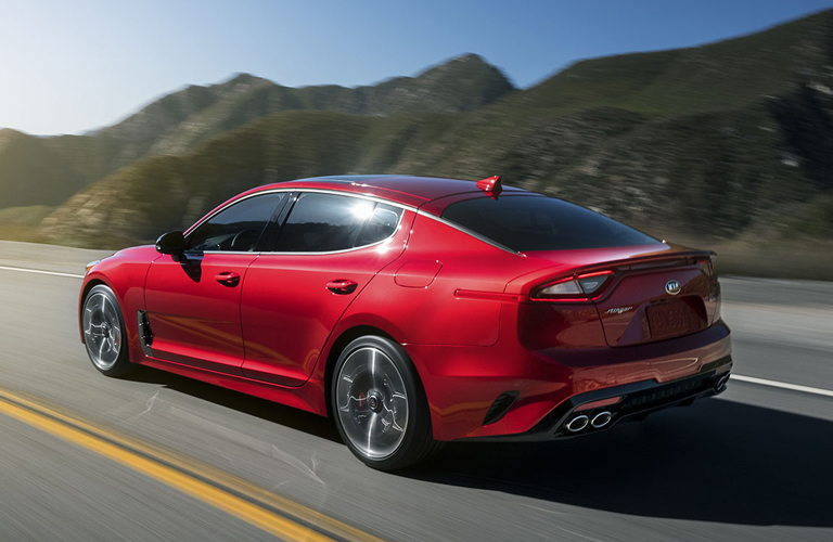 Red 2019 Kia Stinger driving down a highway