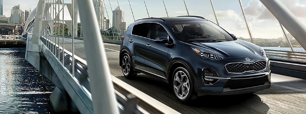 2020 Kia Sportage grey driving on bridge over river