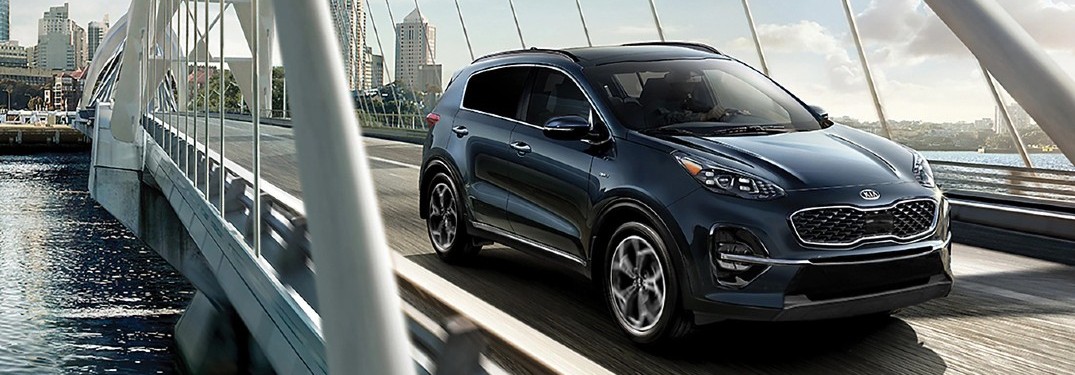 2020 Kia Sportage grey driving on bridge over river
