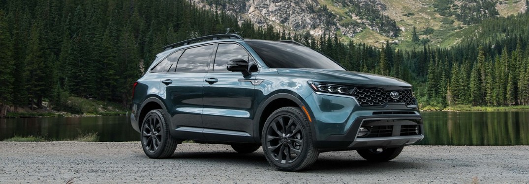 2021 Kia Sorento dark blue parked in front of forest lake