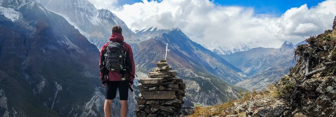 Man hiking in forest trail and viewing the mountain