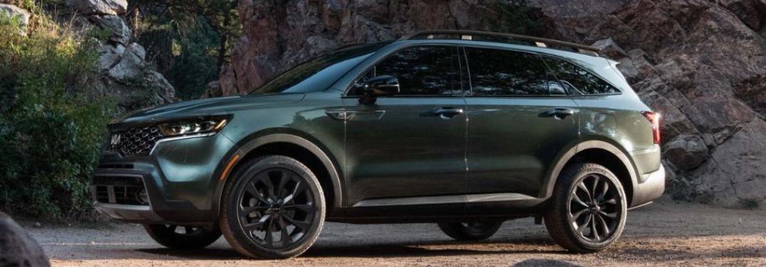 2022 Kia Sorento Green parked in the forest with rocks on background