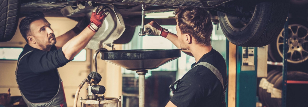 Two men completing an oil change service