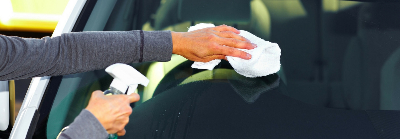 A person cleaning off their windshield featured in a blog post about spring cleaning