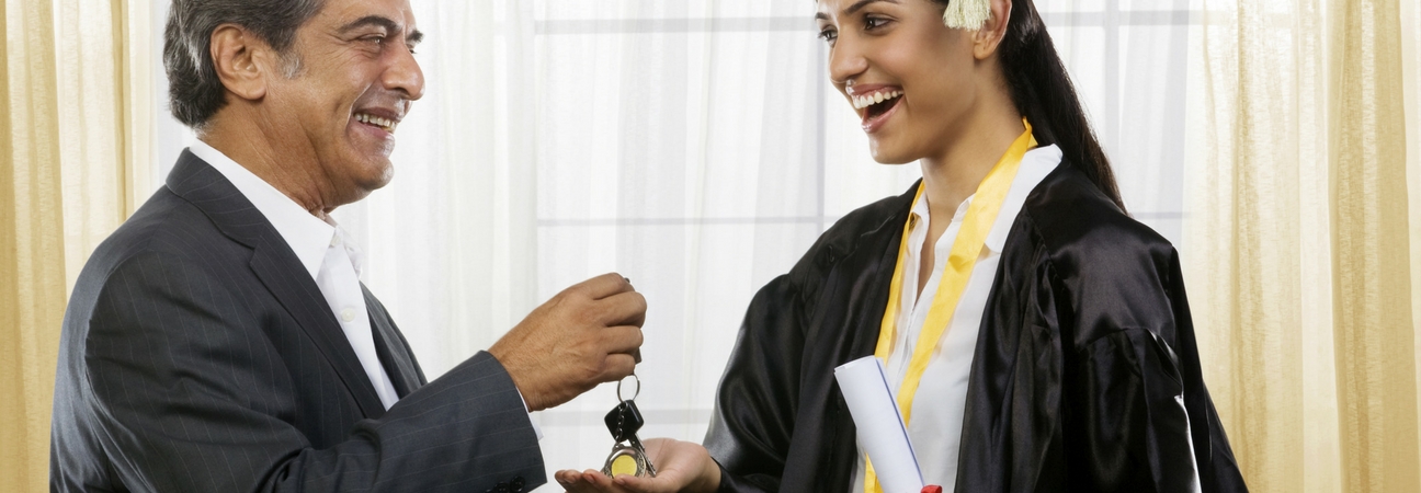 A salesman handing a woman a set of car keys