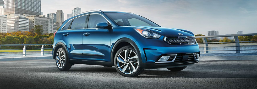 2018 Kia Niro in blue parked in an empty lot near water