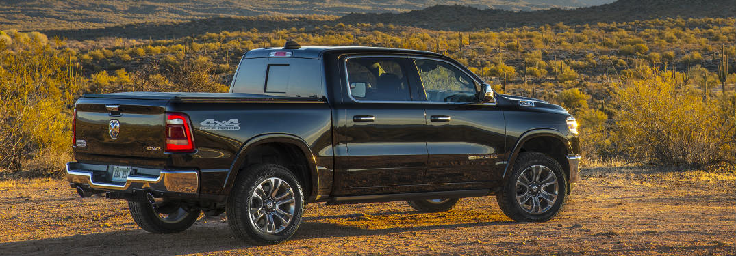 side and rear view of the 2019 Ram 1500 driving through a dry landscape