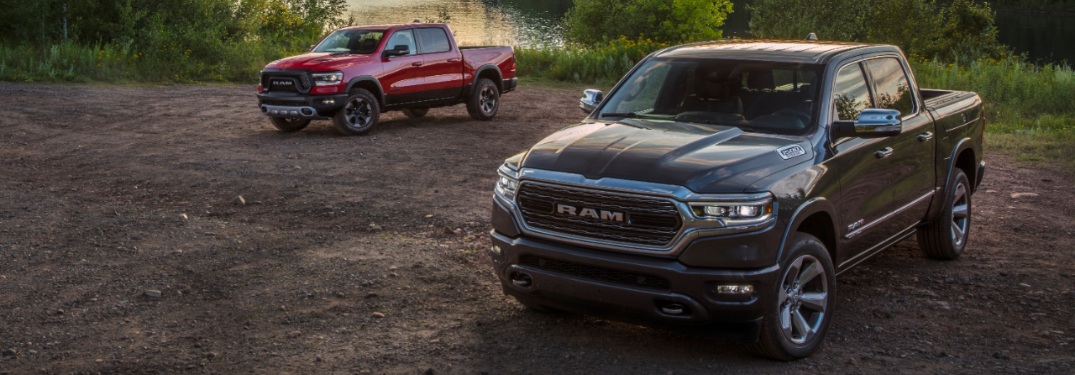 two 2020 Ram 1500 trucks by water's edge