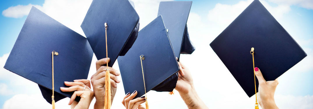 People holding up graduation caps