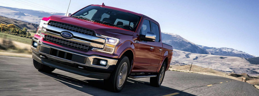 Red 2018 Ford F-150 Lariat driving down mountainous road