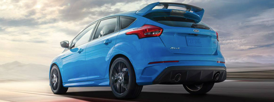Rear shot of blue 2018 Ford Focus RS driving on track road at dusk