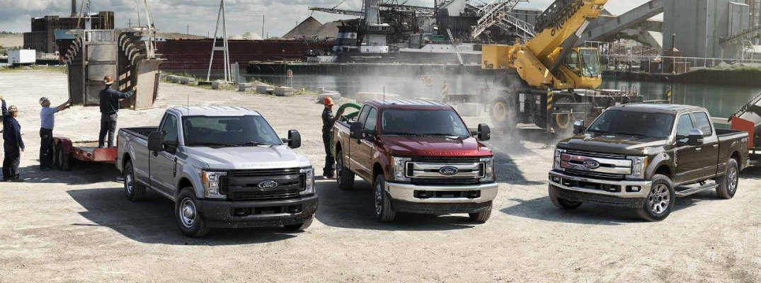 Three Ford Super Duty trucks lined up side by side on worksite