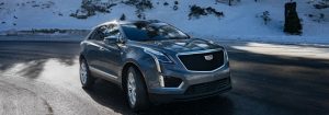 A 2021 Cadillac XT5 driving on mountain road.