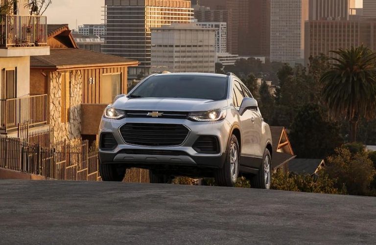 The 2021 Chevy Trax climbing uphill with the city backdrop.