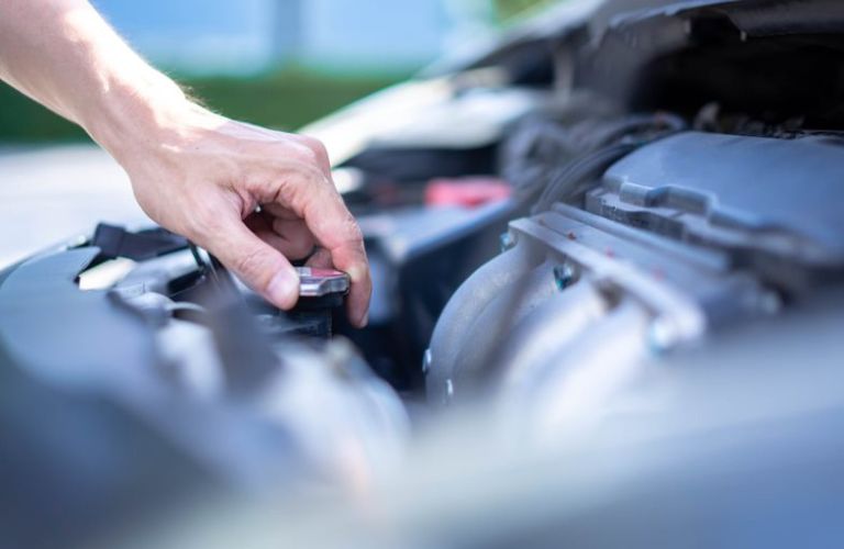 Closing the radiator cap after checking the coolant level