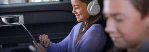 a girl wearing headphones looking at a tablet in a Ford with Connectivity Package