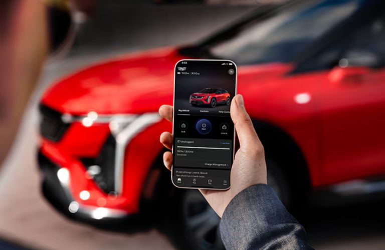 a hand checking the range of the 2025 Cadillac OPTIQ in phone