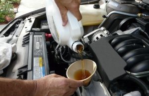 a technician pouring fresh oil in a car