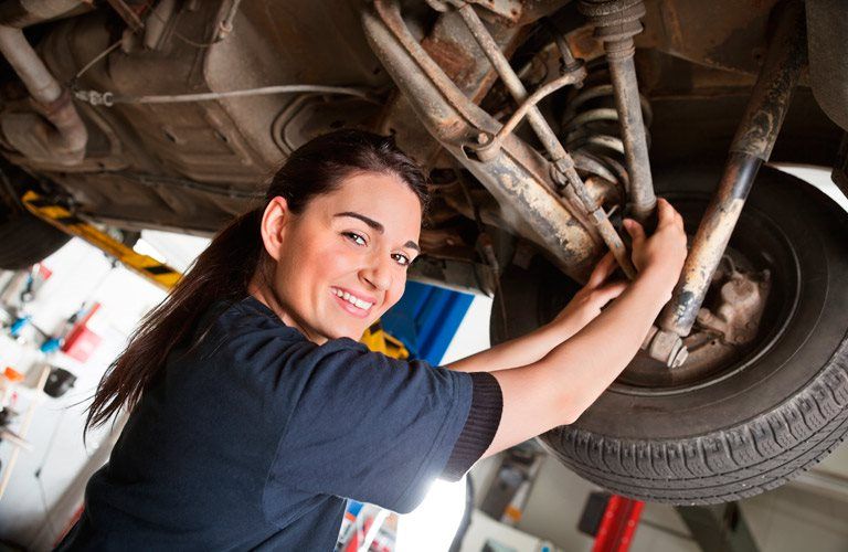 a woman working under a car