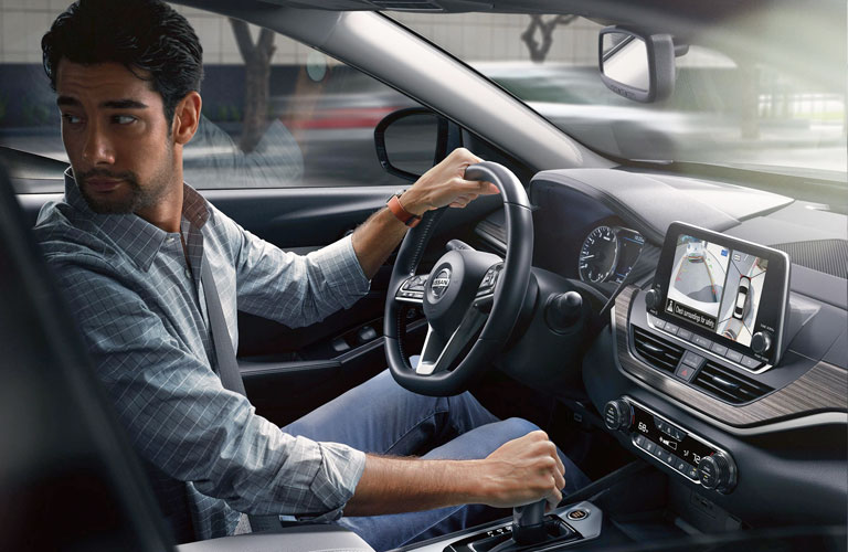 A man sitting behind the wheel of a 2020 Nissan Altima