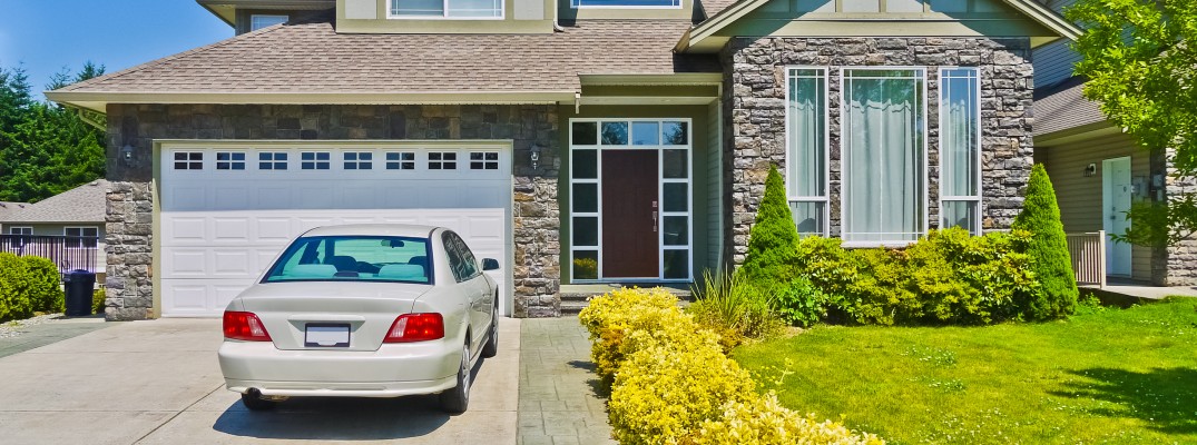 A stock photo of a sedan parked in a driveway.