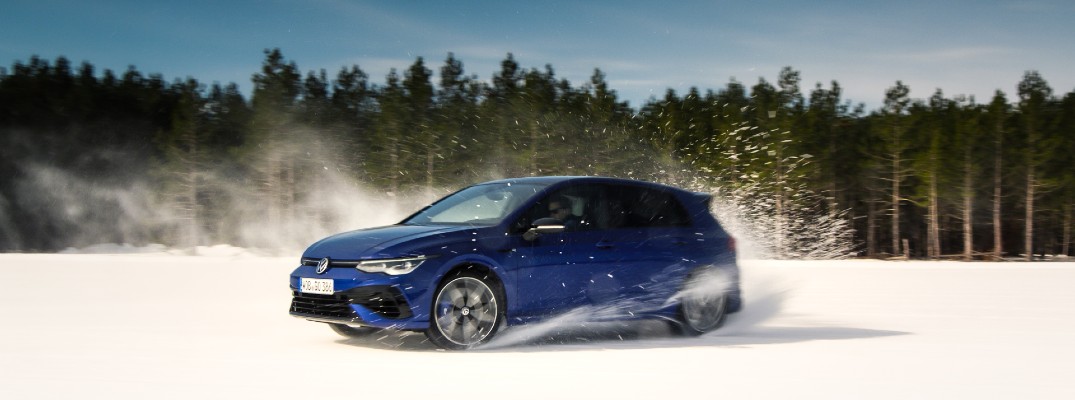 A dynamic photo of the 2022 Volkswagen Golf R sliding through snow.